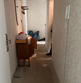 Haushaltsauflösung im Flur mit Möbelstücken und abgestellten Gegenständen während der Wohnungsräumung