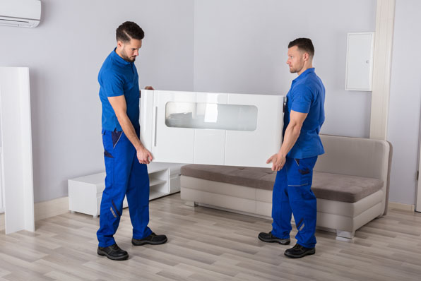 Professionelle Entrümpelung Remscheid für private Haushalte. Zwei Mitarbeiter von Entvita transportieren im Rahmen einer Entrümpelung in Remscheid gemeinsam ein Möbelstück aus einer Wohnung.