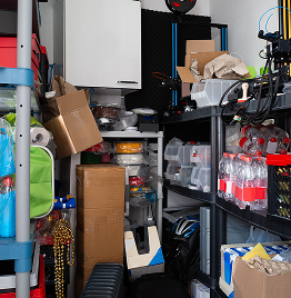 Wohnungsauflösung in Abstellraum mit Regalen, Kisten und gelagerten Vorräten vor der Räumung