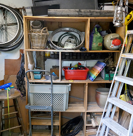 Wohnungsauflösung in Werkstatt oder Keller mit Regalen, Werkzeug und verschiedenen Haushaltsgegenständen