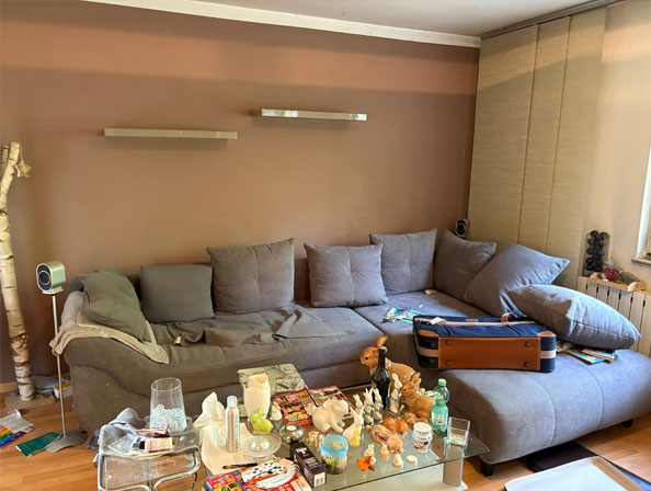 Wohnungsauflösung und Organisation im Wohnraum Wohnungsauflösung Essen: Vollständig möblierter Wohnbereich mit Couch und verstreuten Gegenständen