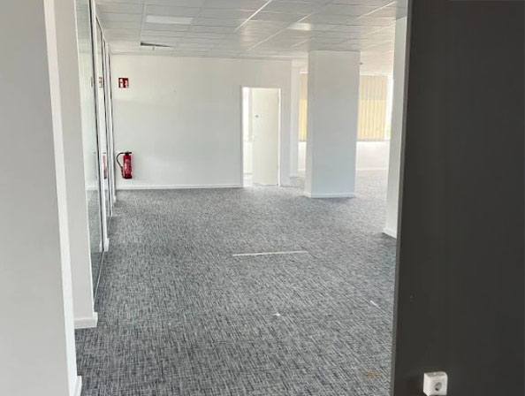 Büroentrümpelung nach Firmenauflösung in Essen Großraumbüro mit leerem Teppichboden und weißen Wänden nach kompletter Räumung