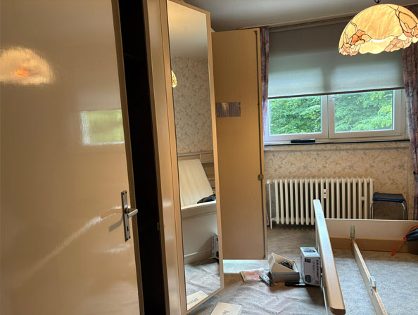 Montage und Demontage im Schlafzimmer – Haushaltsauflösung Essen Halbfertige Haushaltsauflösung in Essen: Schlafzimmer mit zerlegtem Bettgestell und verstreuten Möbelteilen