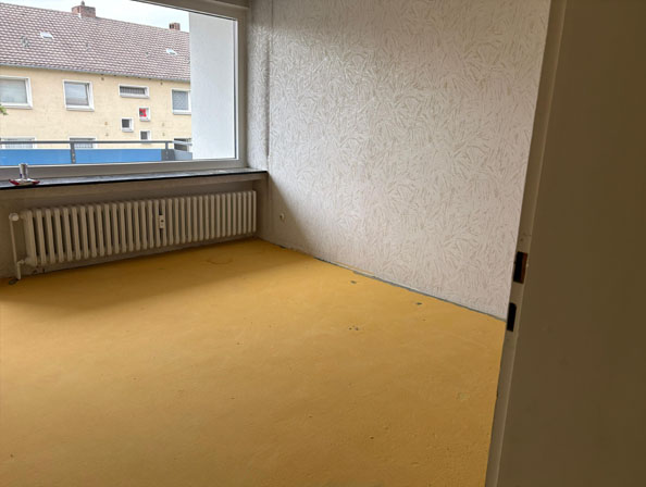 Blitzsaubere Übergabe nach Haushaltsauflösung Essen Kahler Raum mit Fensterblick und Radiator nach kompletter Haushaltsauflösung in Essen